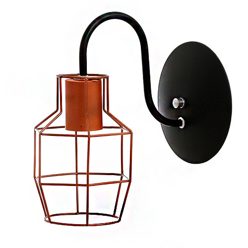 Uma arandela industrial com base circular preta e braço em "S". Na ponta, um bocal cor cobre é envolvido por uma gaiola aramada geométrica também de cobre, que protege a lâmpada. O design une o rústico ao moderno com linhas finas e metálicas